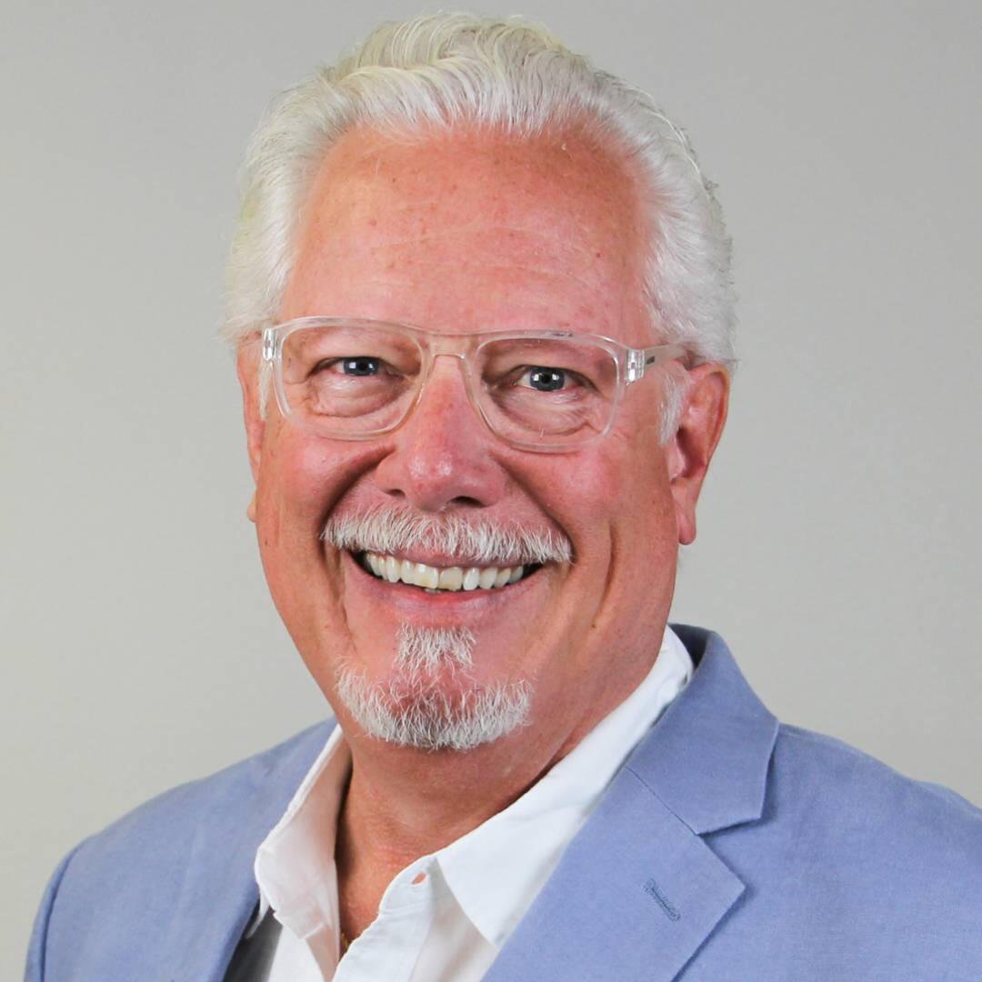 Headshot of an older man with glasses and a goatee
